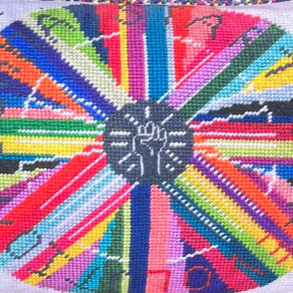 pillow center is dark gray with white fist pump, rainbow circle radiates out with GONNA START A REVOLUTION, cloud and stars border