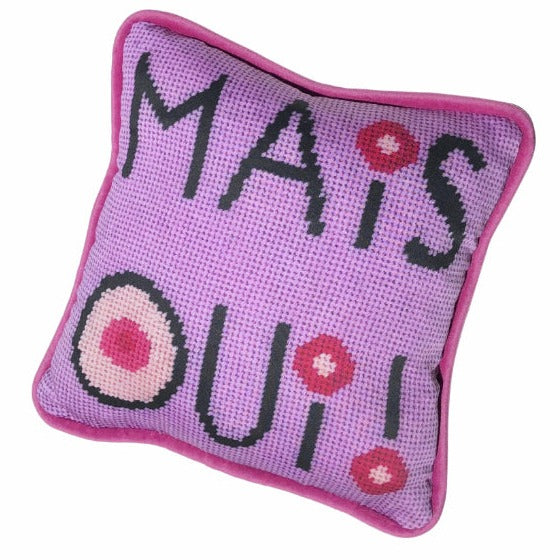 mais oui black stacked text with I dot and O that have cream colored centers with pink circles. Lavender pink background