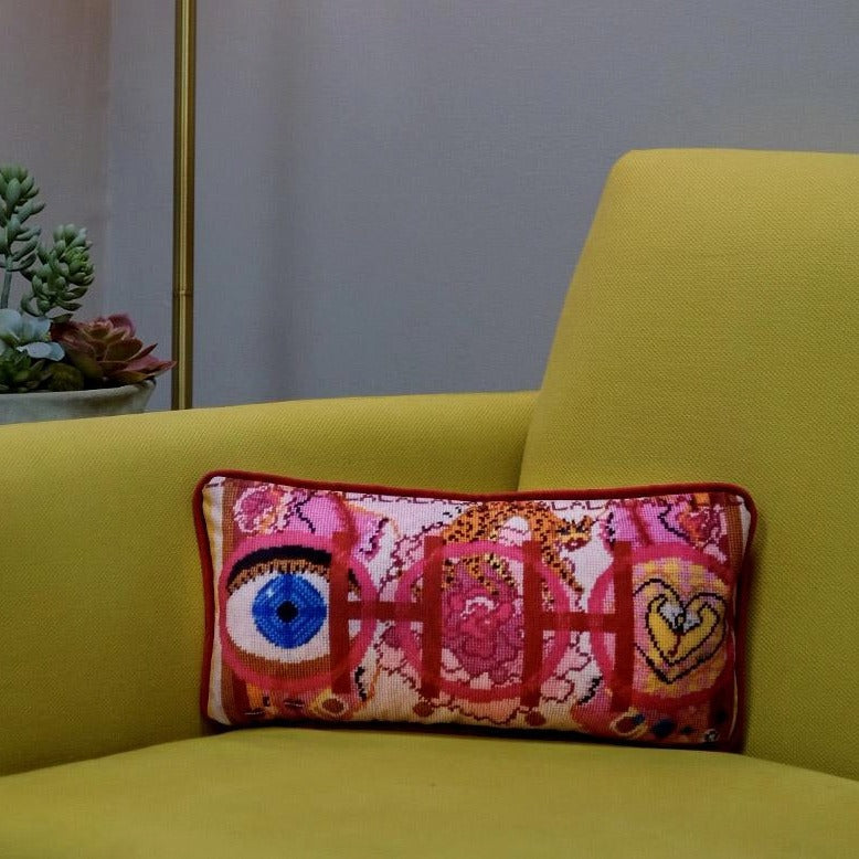velvet pillow with pink and red colorful pattern, blue eye, cheetah, heart snakes, roses and lettering OOH in center with a LA LA LA border modern chartreuse sofa