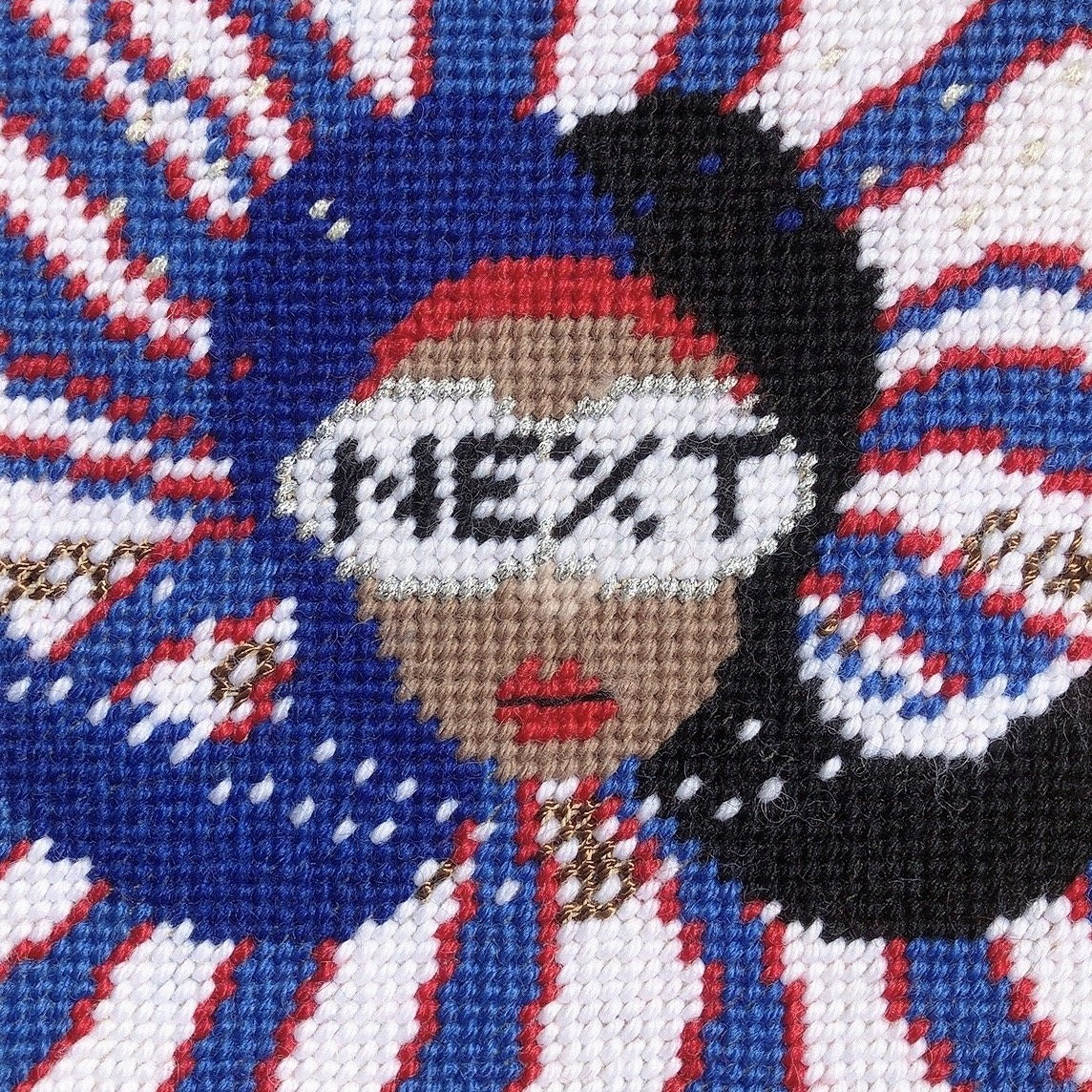 red, white & blue pillow with lady centered, flipped black hair, pearl necklace and sunglasses that say NEXT