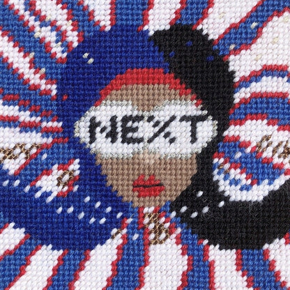 needlepoint red, white & blue pillow with lady centered, flipped black hair, pearl necklace and sunglasses that say NEXT