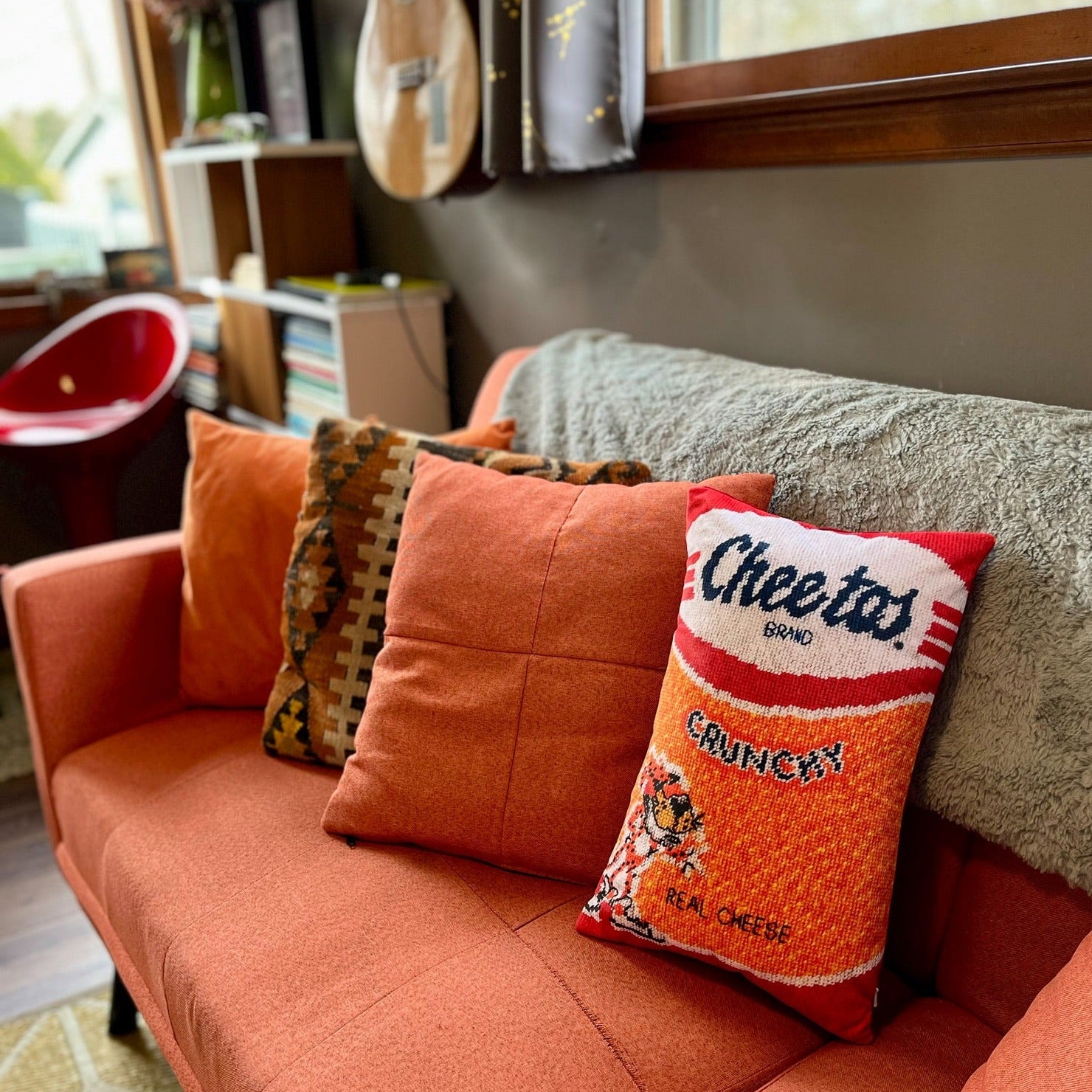 Cheetos pillow with crunchy logo & Chester on modern couch