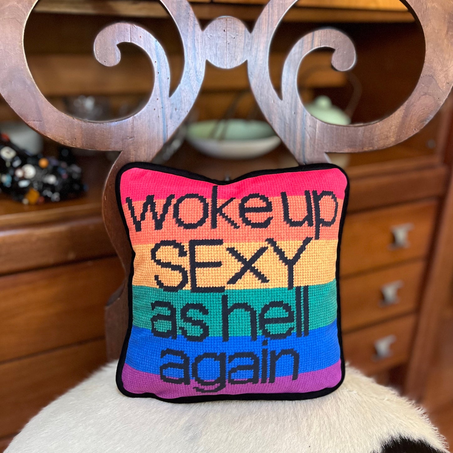 black text with woke up sexy as hell again centered on pillow on rainbow flag background