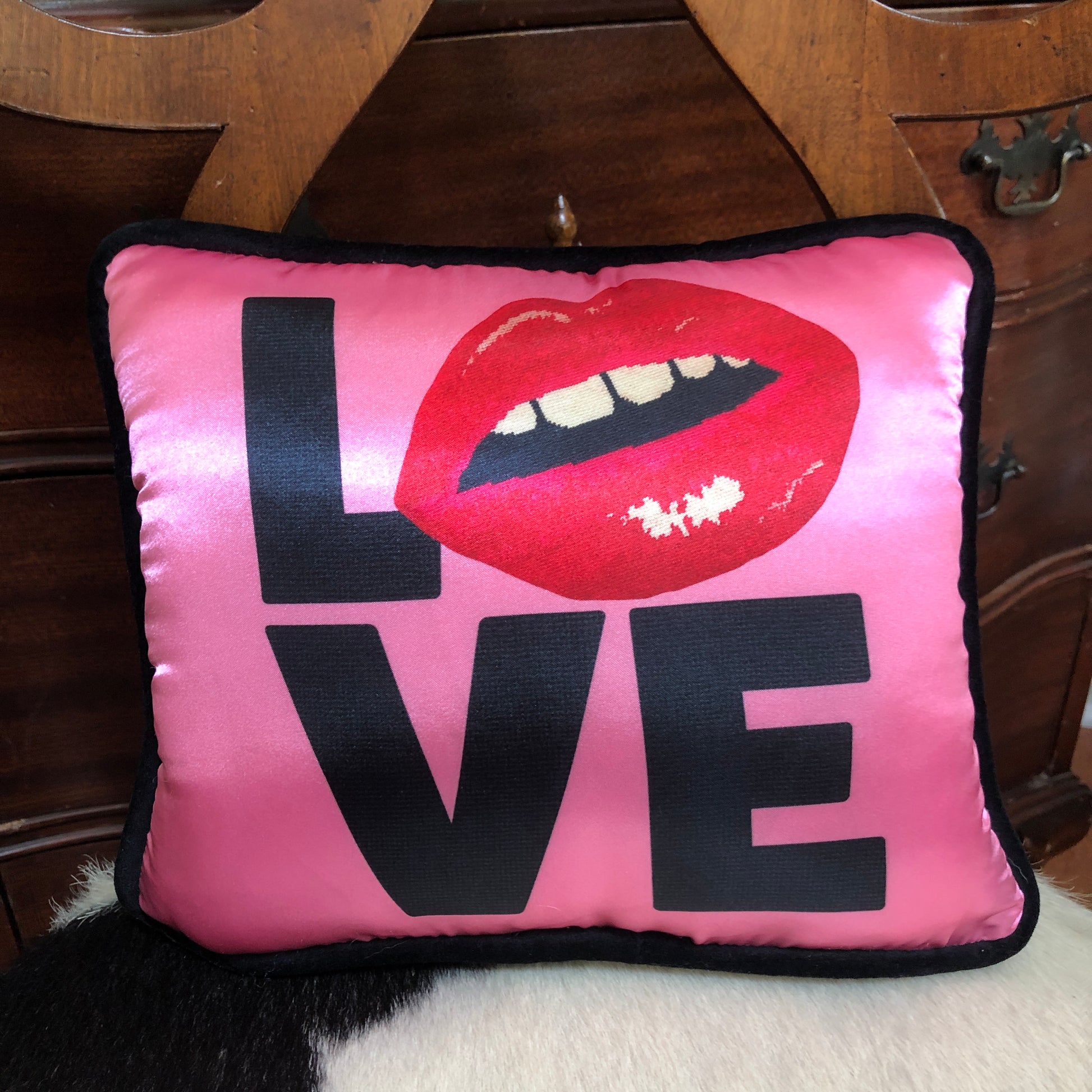 hot pink pillow with blackletters - L, red lips for an O, V & E stacked underneath