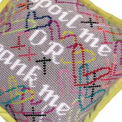 needlepoint SPOIL ME OR SPANK ME in white, surrounded by brightly colored hearts and a soft gray background